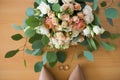 Wedding bouquet with beige and pink roses in focus near lying wedding rings, brideÃ¢â¬â¢s beige shoes. Royalty Free Stock Photo